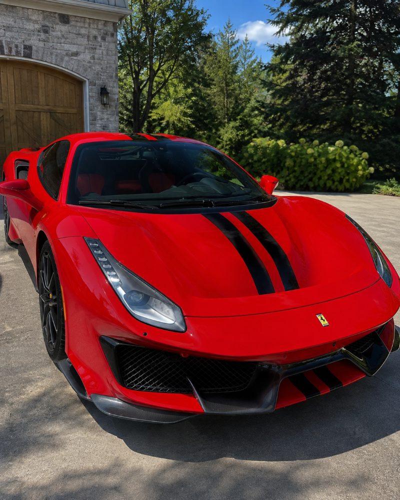 A red Ferrari parked on a driveway after a detail