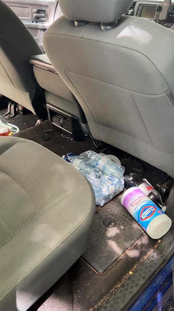 A cream cloth interior before cleaning, with rubbish and staining in the footwell