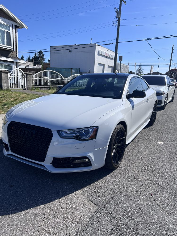 A white Audi S4 parked on the street after a detail